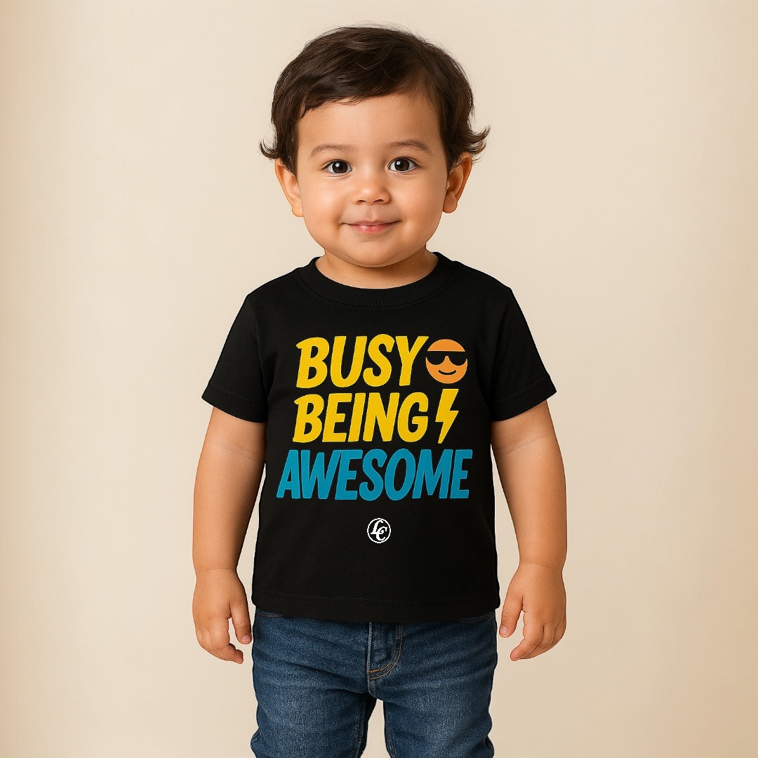Child wearing a black t-shirt with colorful text on a beige background