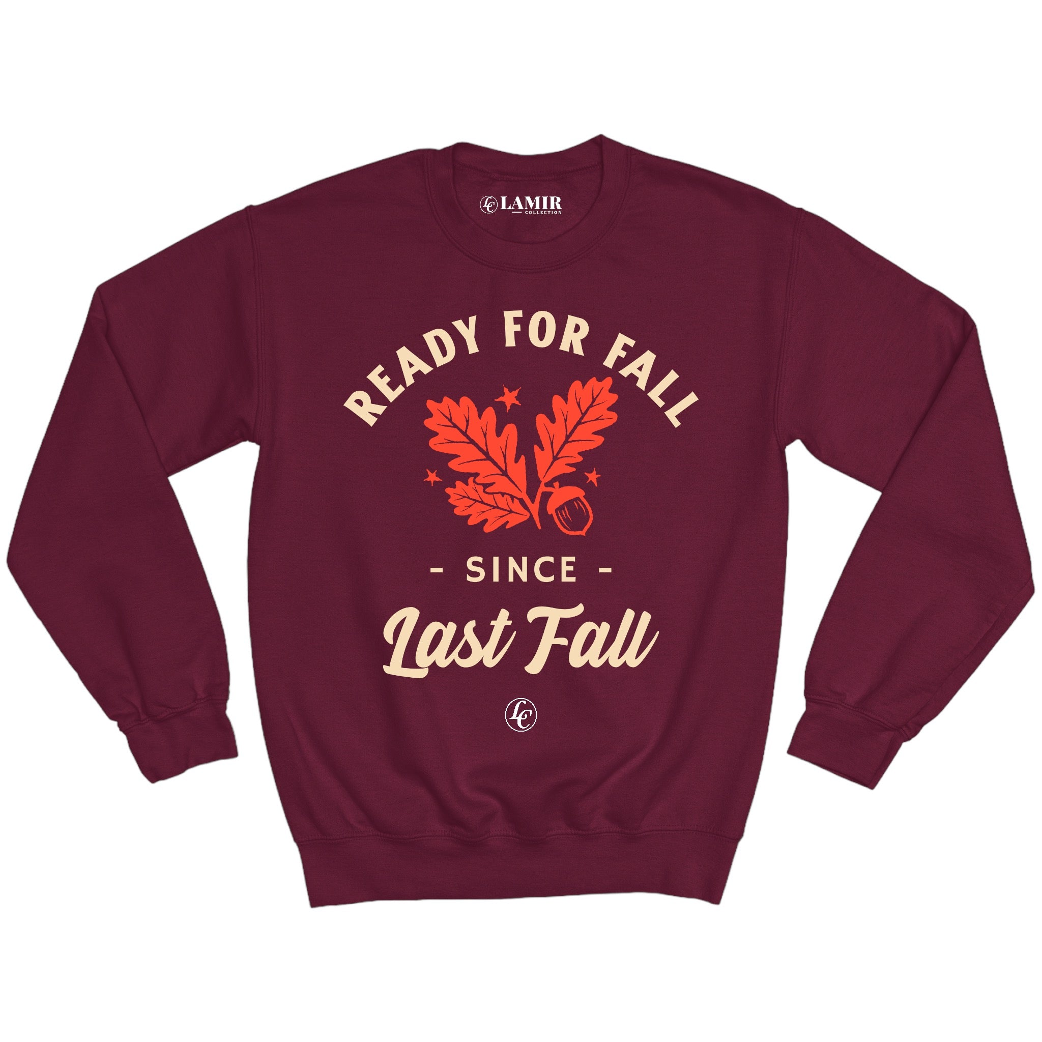A maroon crewneck sweatshirt with the text 'READY FOR FALL SINCE LAST FALL' printed on the front, displayed against a backdrop of a cloudy sky and autumn leaves.