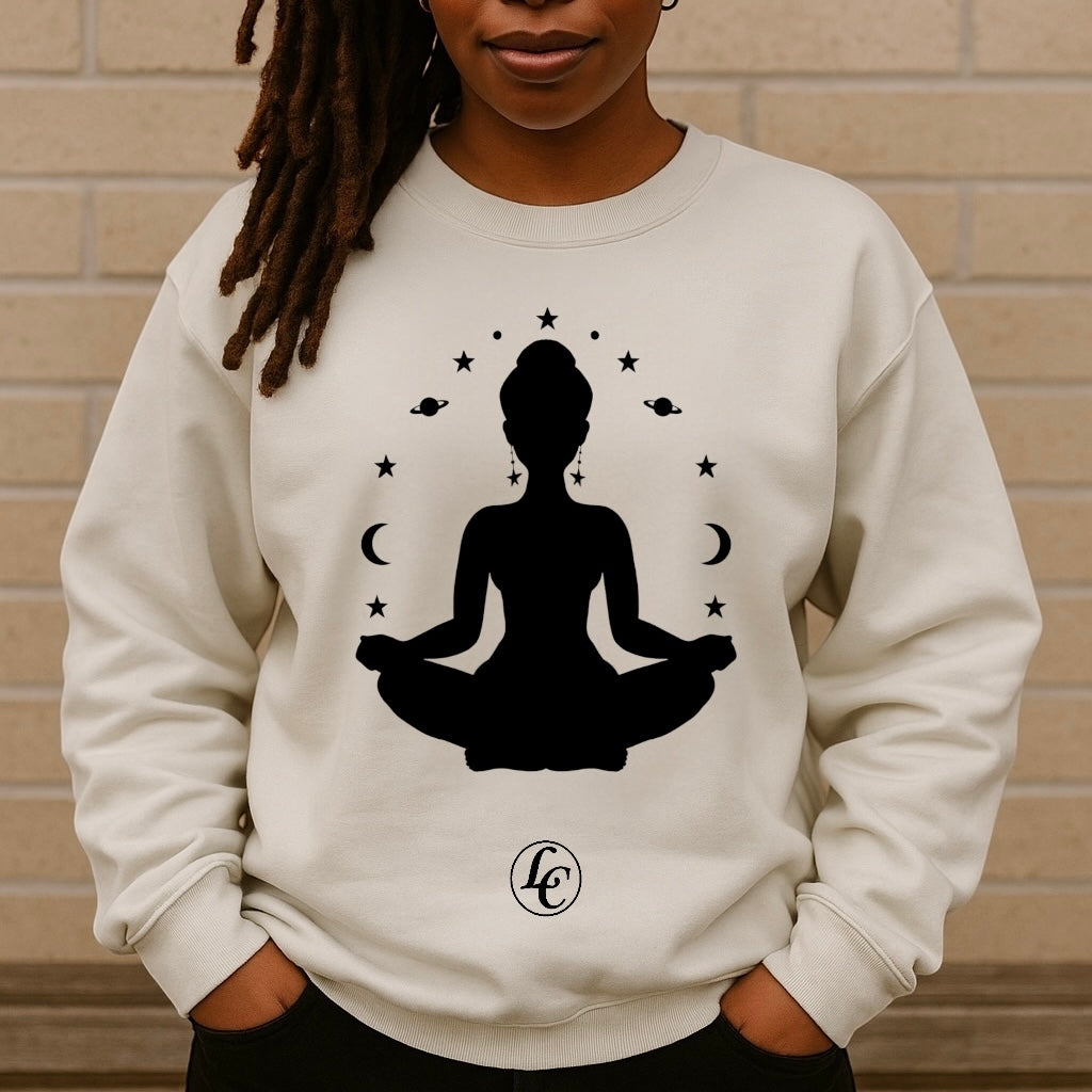 Person wearing a white sweatshirt with a black silhouette of a meditating figure and celestial design.