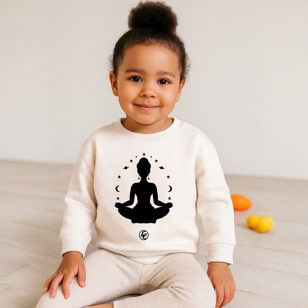 Child wearing a white sweatshirt with a black silhouette design on a light background