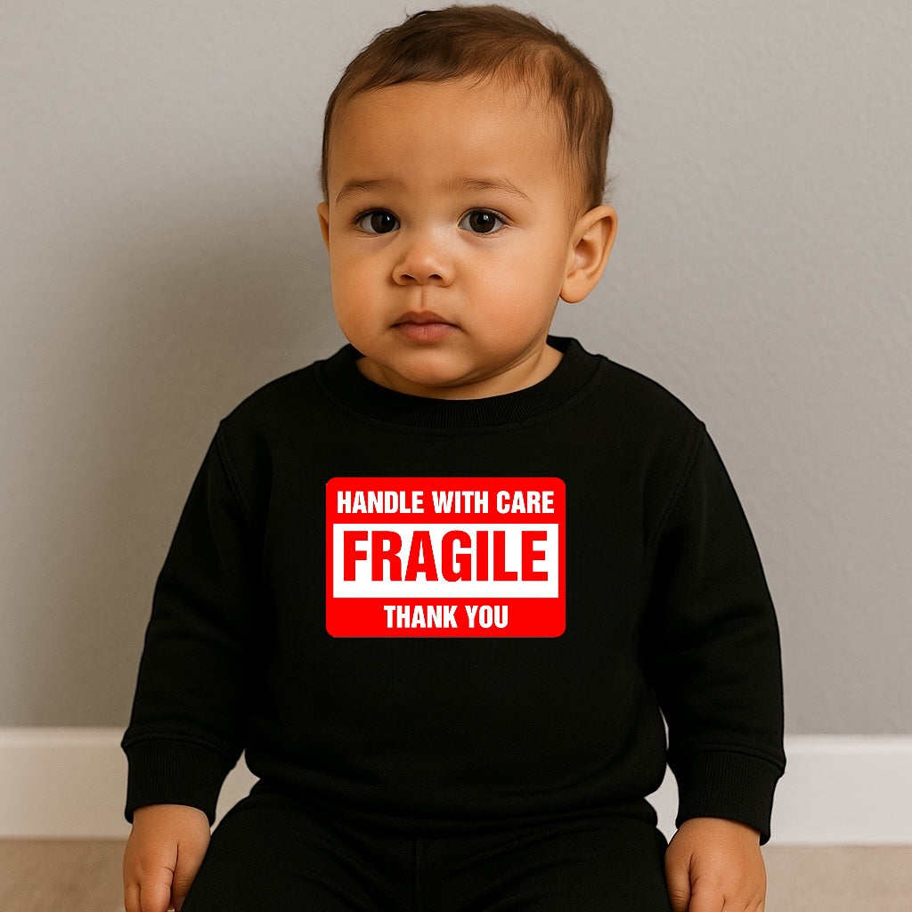 Baby wearing a black shirt with a red and white 'Fragile' label design.