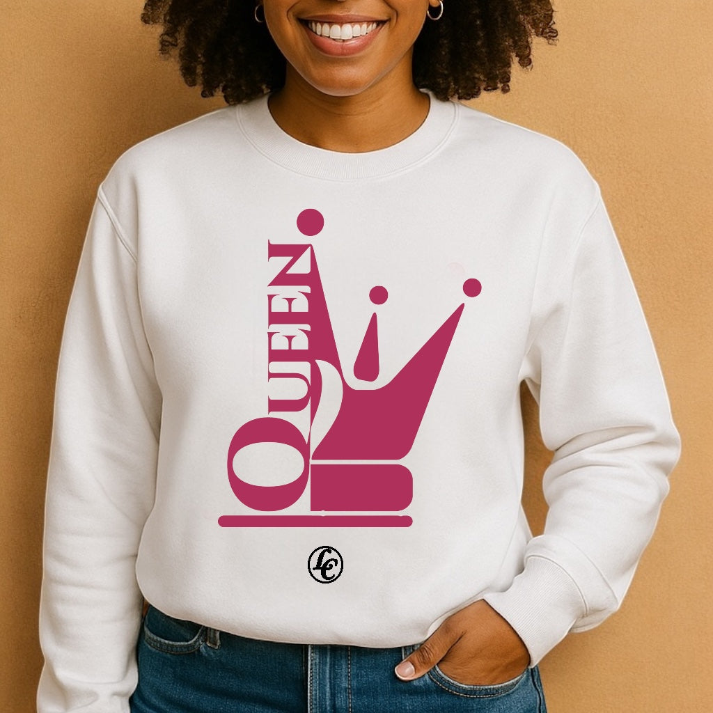 Person wearing a white sweatshirt with a pink 'QUEEN' design on a beige background