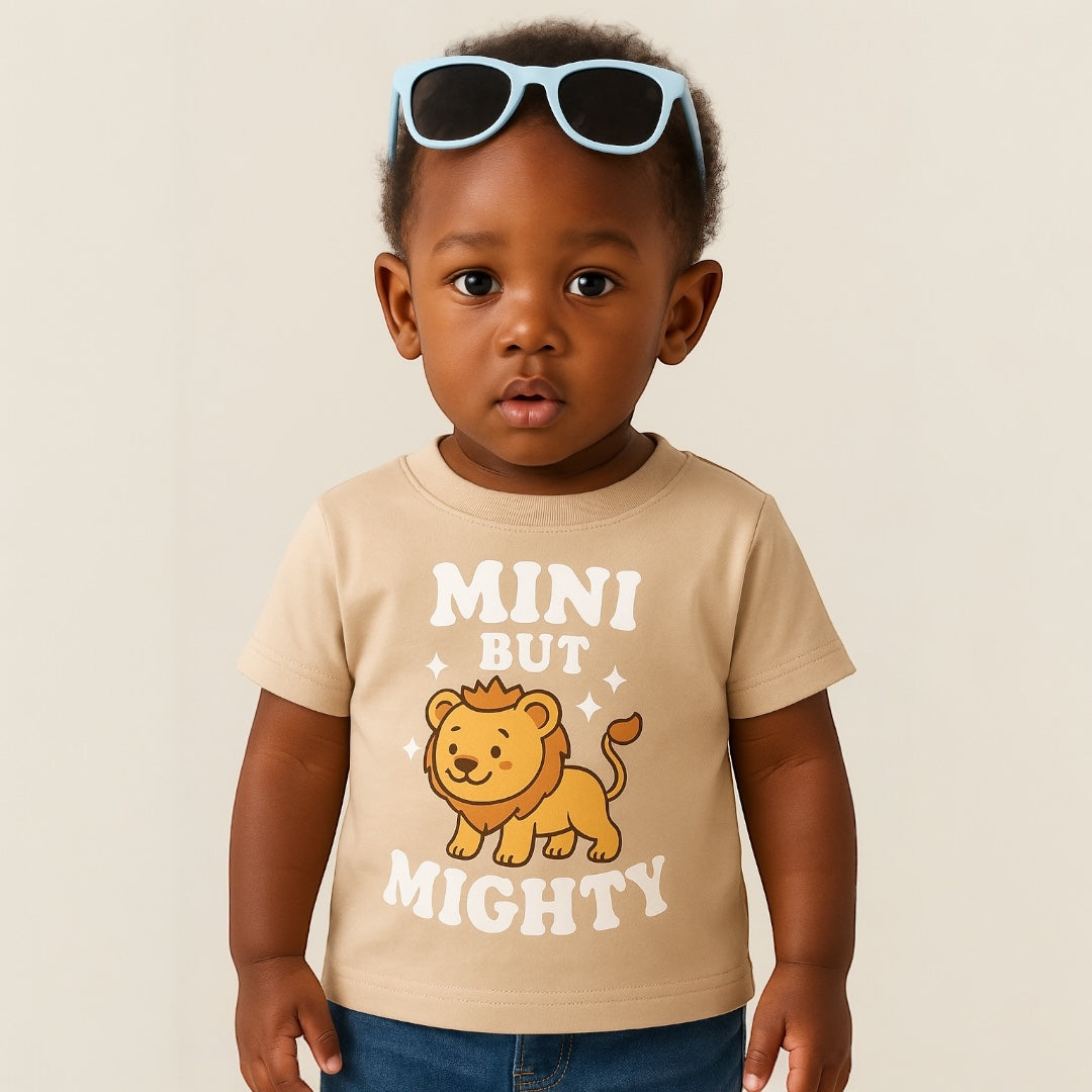 Child wearing a beige t-shirt with a lion graphic and text, standing against a plain background.